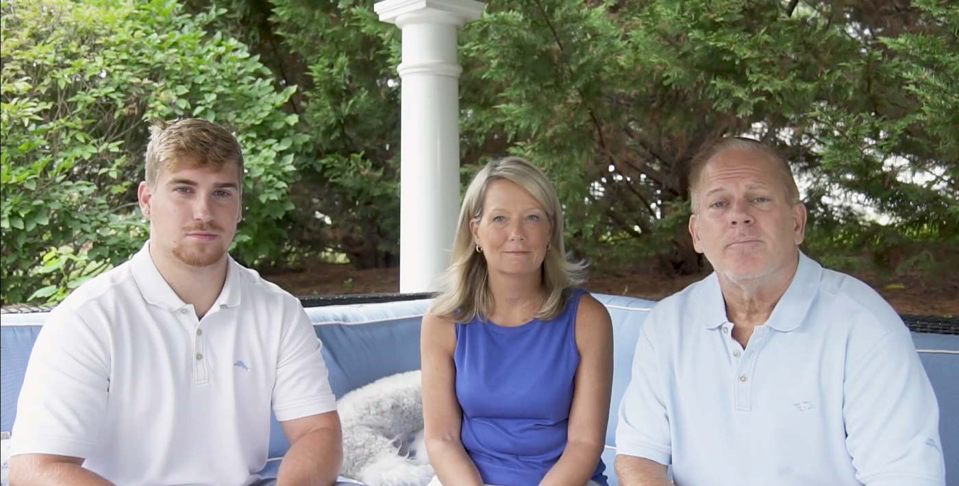 A family of three seated outdoors