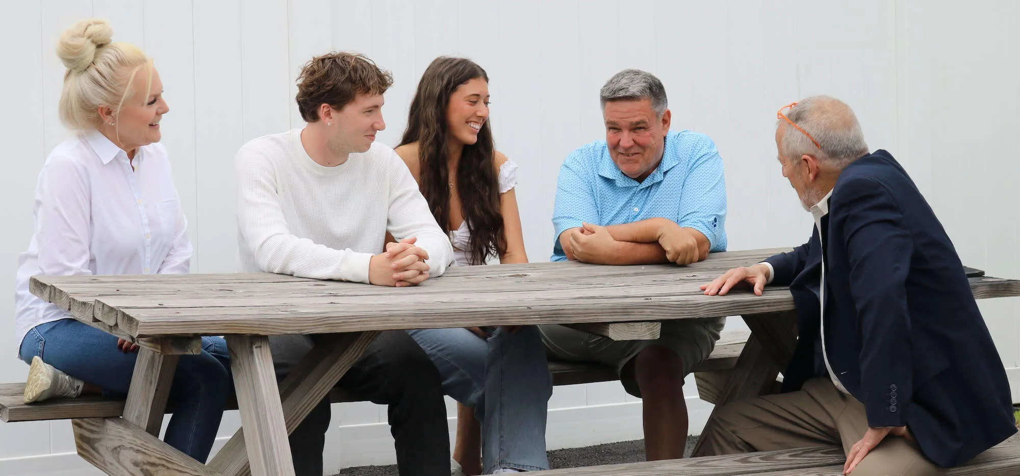 Jeff Levin talking with a family of five around a picnic table