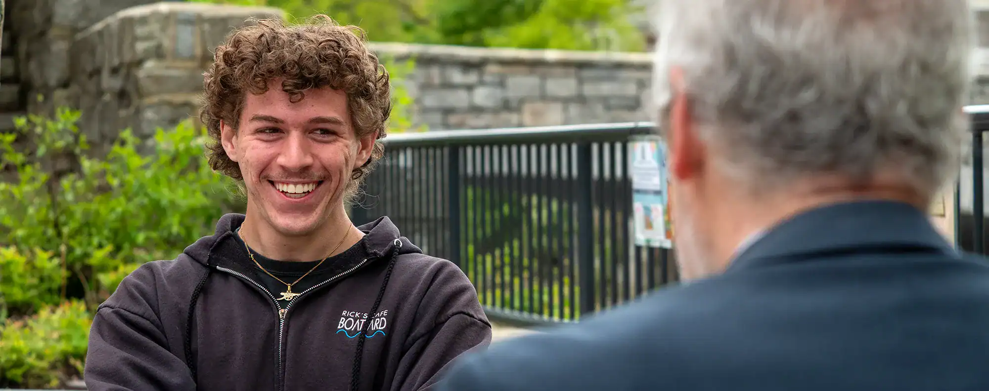A smiling young man in conversation with Jeff