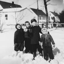 Children standing together in the snow, 1971